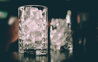 Ice cube in an empty glass on a bar counterin bar or pub