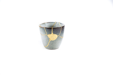 kintsugi gold cracks restoration, Japanese bowl fixed with the antique kintsukuroi restoration technique, the beauty of imperfections, representation of a trauma