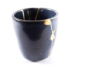 kintsugi gold cracks restoration, Japanese bowl fixed with the antique kintsukuroi restoration technique, the beauty of imperfections, representation of a trauma