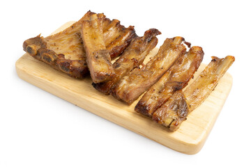 Homemade Roasted Honey Glazed Rack and Pieces of Pork Ribs, famous for Octoberfest party dinner serving on wooden board isolated on white background. Clipping path.