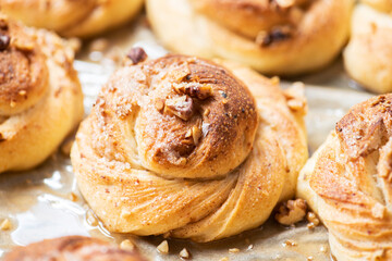 Freshly baked nuts and cardamom sweet buns. Yeasted pastry and cozy baking.