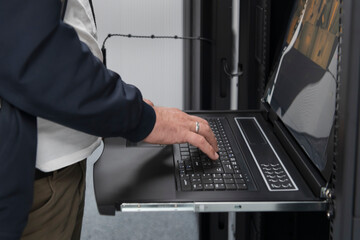 Close up on Data Center Engineer hands Using keyboard on a supercomputer Server Room Specialist...