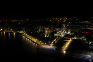 Aerial view of the city of Thessaloniki at night with famous White Tower in the background.