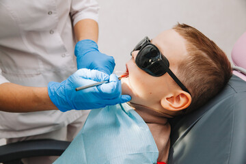 Medicine, dentistry and healthcare concept. a dentist with a dental drill and a saliva ejector...