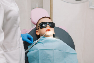 Medicine, dentistry and healthcare concept. a dentist with a dental drill and a saliva ejector...