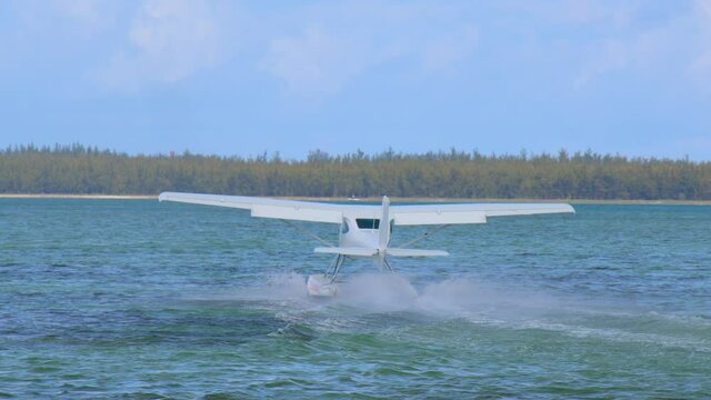 White hydroplane takeoff in a calm lagoon