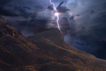 lightning strikes a desert hill at night