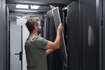 IT engineer working In the server room or data center The technician puts in a rack a new server of corporate business mainframe supercomputer or cryptocurrency mining farm. 