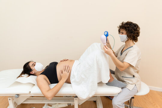 Gynecologist Holding A Pelvic Floor Muscle Exercise Device To Prepare For The Giving Of Birth Of A Woman Lying