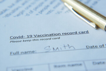 vaccination record card , hand sanitizer and mask on color background 