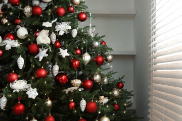 Fototapeta na wymiar Beautifully decorated Christmas tree near window indoors