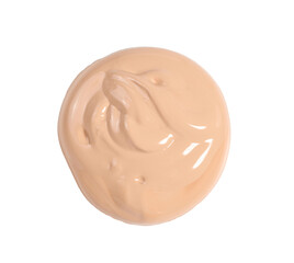 round swatch of light brown face cream on white background, top view