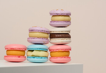 baked round macarons on a beige background, delicious dessert, bottom view