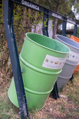 Naklejka premium Spanish signs above colorful trash cans in park
