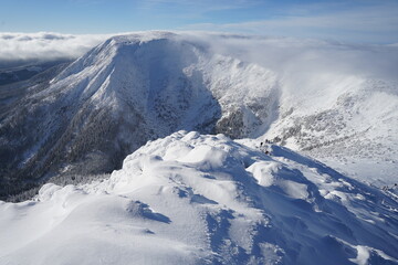 Beautiful Giant Mountains covered with snow on winter sunny day and blue sky, panoramic view from Sniezka Mountain, Poland