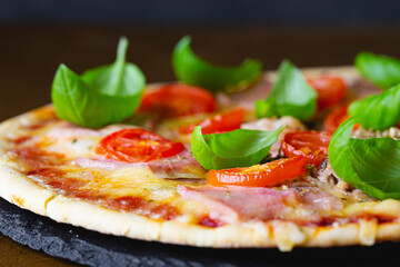 Thin crust pizza with fresh basil close-up