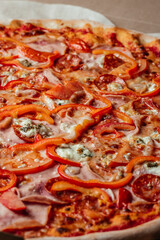 Background pizza. Hot big pepperoni pizza tasty pizza composition with melting cheese bacon tomatoes ham paprika. vertical image. top view. place for text