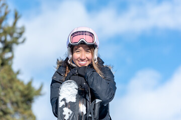 Latin woman in the mountains with skies on a sunny day