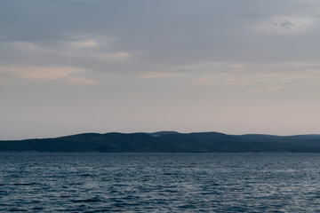 Obraz premium Seascape with wavy Adriatic sea and Brac island silhouette in Croatia at dusk