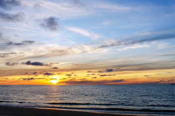 Naklejka premium Sunset over the sea. Reflection of sunlight in the sea waves. The sky in the sunset rays. Baltic Sea.
