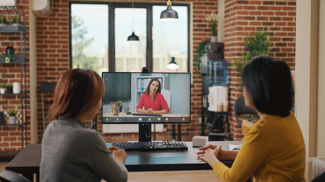 Colleagues using video call conference to recruit woman at online job interview. Workmates attending remote videoconference meeting on computer to hire intern with work contract.