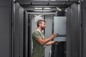 IT engineer working In the server room or data center The technician puts in a rack a new server of corporate business mainframe supercomputer or cryptocurrency mining farm. 
