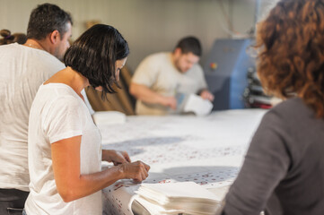 Group of workers, female and male, work together in factory