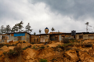 Golden Buddha head above slum houses in Thimphu, Bhutan, Asia