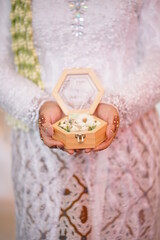 Fototapeta na wymiar Engagement ring box in bride hands. Closeup of woman palms holding jewellery. Love, Wedding, Proposing, Marriage concept. Rustic chic style
