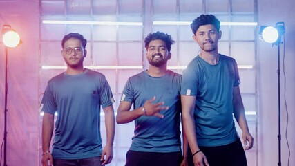 Team of professional gamer entering stage or arena in attitude by showing different hand gestures while looking at camera during championship tournment on neon light background -