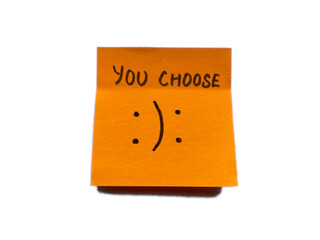 Sticky note with text You Choose and happysad smileys on white background.