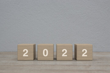 2022 letter on wood block cubes on wooden table over white wall background, Happy new year 2022 cover concept