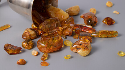 Transparent Baltic orange amber stones on a gray background. Isolated ancient fossil. 