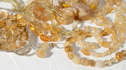 Variety of transparent natural yellow  citrine jewelry on a white plastered background. 