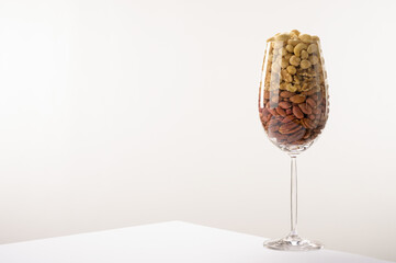 Glass jar filled with a variety of nutrition and healthy snacks and nuts on a white background