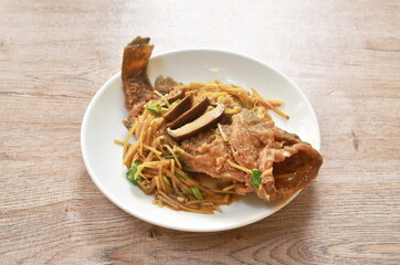 batter fried red grouper fish dressing ginger with mushroom in soy sauce on plate