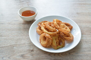 batter fried onion ring on plate dipping chili sweet sauce