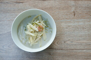 spicy boiled slice fresh bamboo shoot with Acacia leaf in coconut milk soup on bowl
