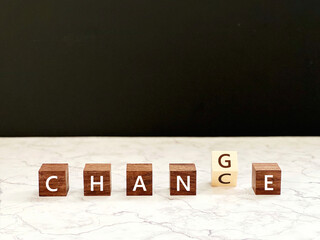 5つ目が傾いた6個の木の立方体_大理石の上_CHANCEとCHANGEの文字入り
