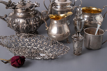 Variety of shining luxurious old silverware on a dark gray background. Retro composition. Isolated antique kitchenware.