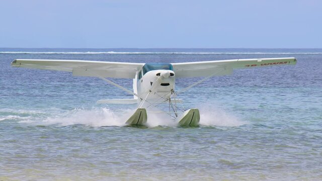 White sea plane landing in a calm lagoon