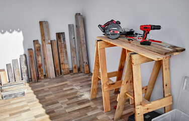 Electric cordless drill with other tools on the wooden table