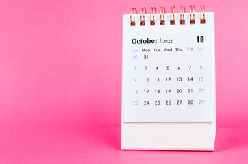 October 2022 desk calendar on pink background.