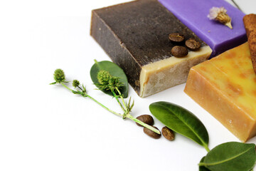 top view of various handcrafted soap with different ingredients in row on white surface.