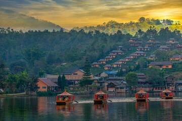 Boats in foreground and sunset over the hills in Ban Rak Thai
