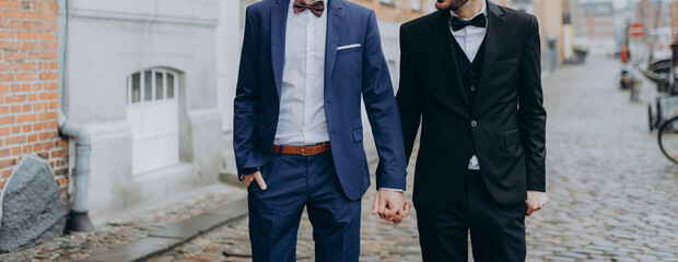 Gay Couple wearing black and blue suits, happy day of a same sex couple. Wedding photography.