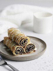 Poppy seed crepes (blinis). Pancakes with poppy feeling for maslenitsa on white textured background