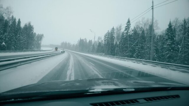 POV car shot in winter. Driving along empty forest highway in Moscow Region, Russia