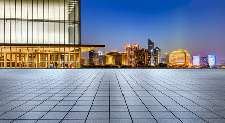Panoramic skyline and modern commercial office buildings with empty square floors at night