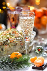 Traditional Russian Christmas Salad Olivier with champagne and tangerines